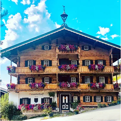 Bauernhaus mit Holzfassade und Blumenbalkonen